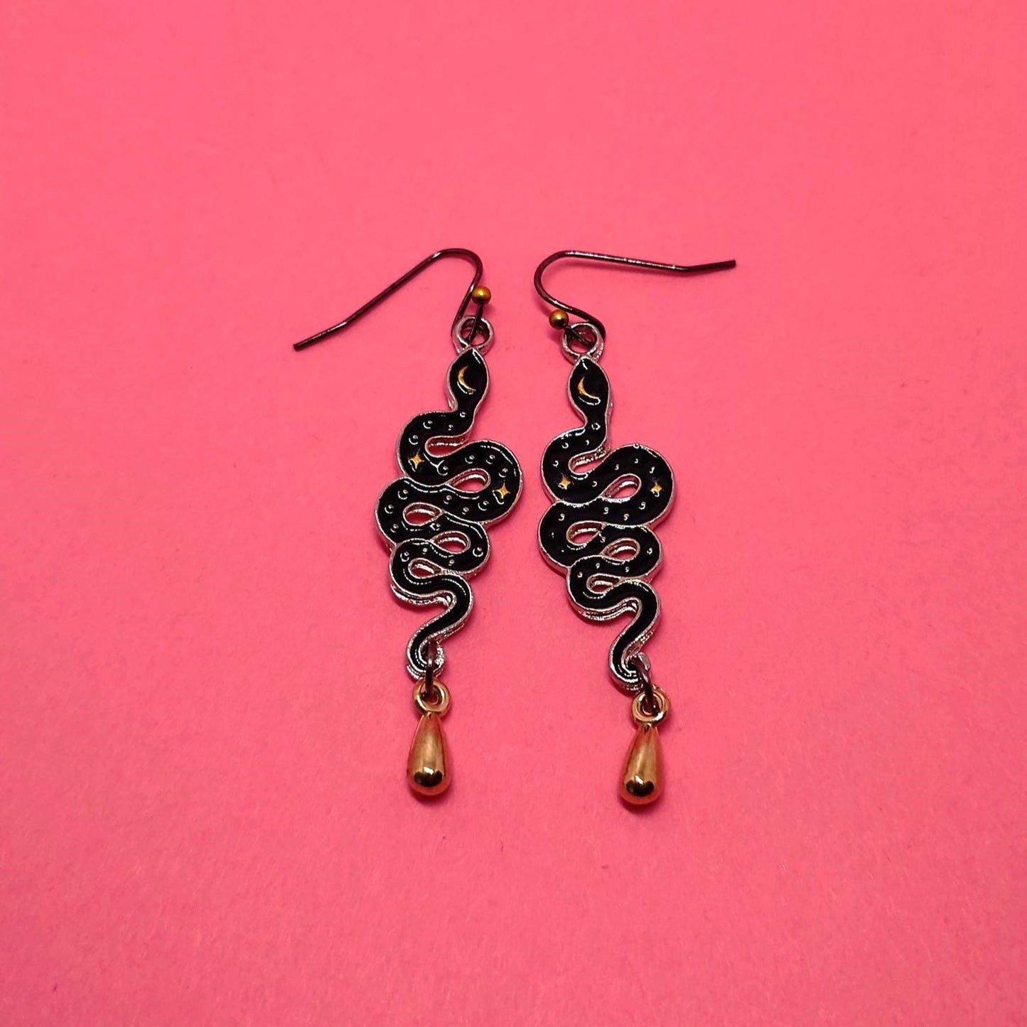Gold and black moon child snake earrings.