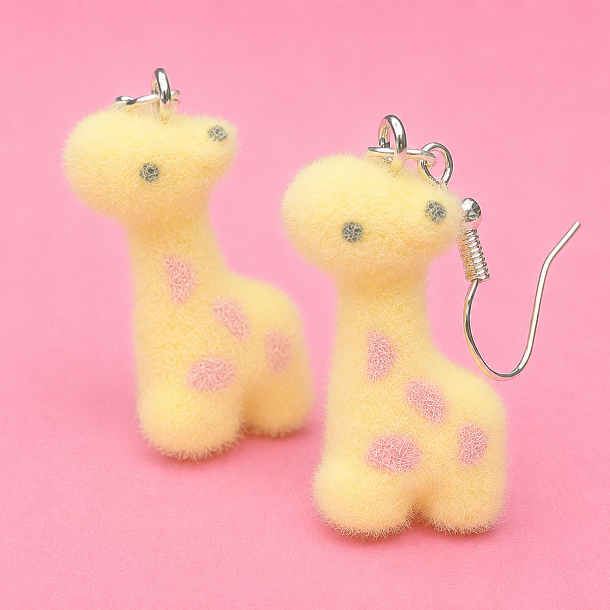 Two yellow plush keychains with pink polka dots on a pink background